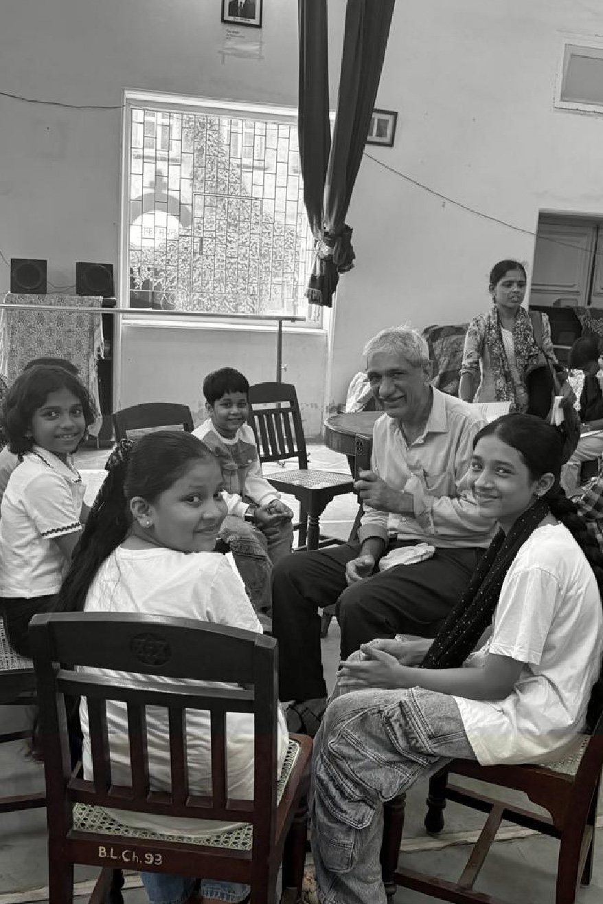 Sponsored children and a volunteer seated together in a classroom
