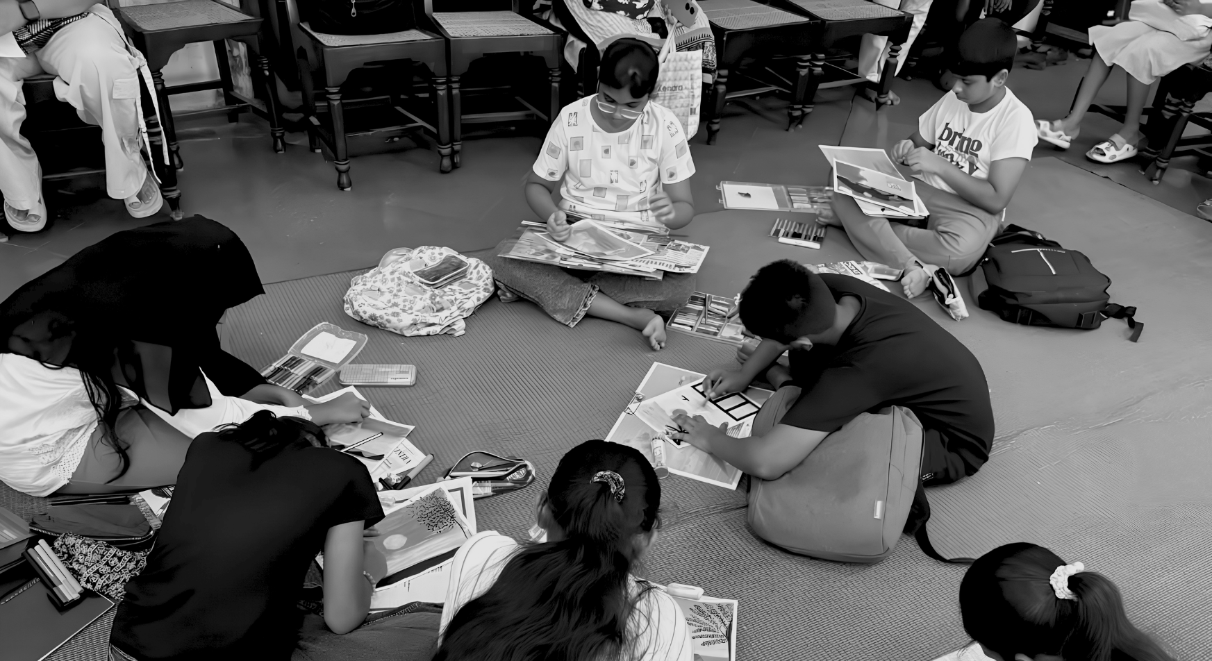Students seated on the floor sketching and painting during a talent nurturing workshop